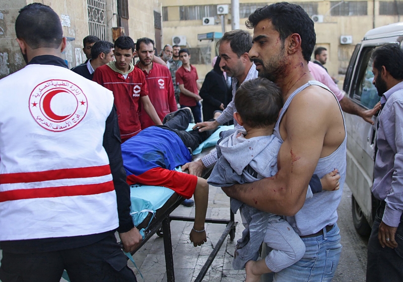 جرحى ينتظرون العلاج أمام أحد المشافي الحكومية في حلب أمس (أ ف ب)
