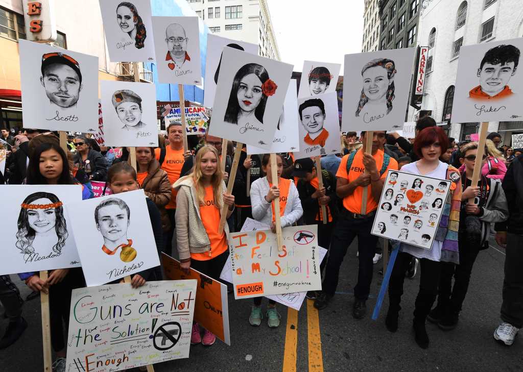طلاب يرفعون صور ضحايا مجزرة «ستونمان دوغلاس» خلال مسيرة كاليفورنيا