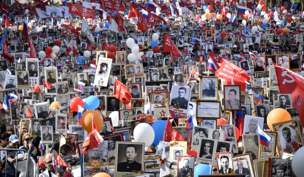 مشاركون يحملون صور أقاربهم من الجنود الذي شاركوا في الحرب العالمية الثانية في مسيرة «الفوج الخالد» في وسط مدينة موسكو