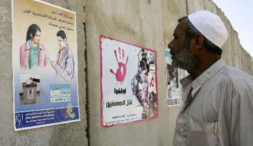 عراقي يقرأ لافتة انتخابيّة في بغداد أمس (علي السعدي ـــ أ ف ب)