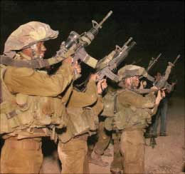 جنود اسرائيليون يجهزون اسلحتهم قبل عبور الحدود اللبنانية (أ ب)