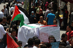 متظاهرون فلسطينيون يحملون مجسم لنعش في رام الله امس (عباس موماني ـ أ ف ب)
