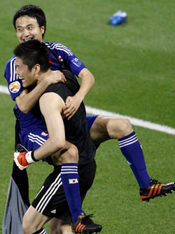 الحارس الياباني كاواشيما يحتفل مع زميله كونو بالتأهل (أوليغ بوبوف ـــ رويترز)