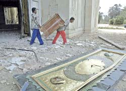 ينهبون ما تيسّر لهم من القصر الرئاسي العراقي في بغداد في 11 نيسان 2003 (أرشيف ـ أود أندرسن)
