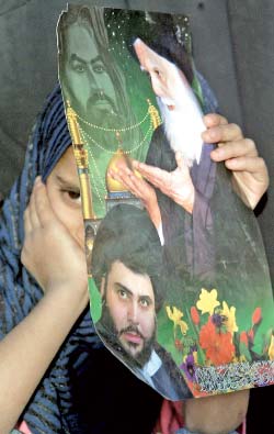 عراقيّة تحمل صورة مقتدى الصدر ووالده محمّد صادق الصدر (أرشيف ـ وسام العقيلي)