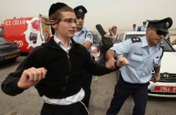 شرطي إسرائيلي يقتاد يهودياً متطرّفاً خلال محاولة لاقتحام خيمة العزاء عن روح الشهيد علاء أبو دهيم في جبل الم