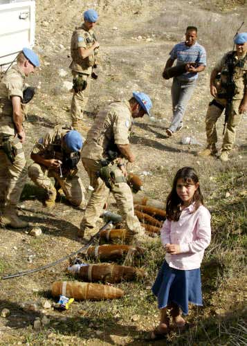 فتاة جنوبيّة تنتظر والدها الذي يعمل مع قوات اليونيفيل على إزالة ذخائر غير منفجرة وقنابل عنقودية في قرية كون