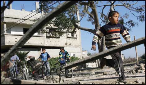 فتى فلسطيني يركض قرب منطقة توغّل عسكري إسرائيلي في خان يونس جنوب قطاع غزّة  (أ ف ب)