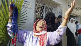 فلسطينية تبكي شهيدتي فك الحصار عن مسجد النصر في بيت حانون أمس (رويترز)