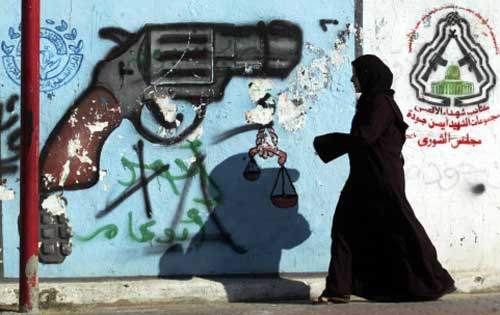 فلسطينيّة أمام جداريّة في أحد شوارع غزّة أمس (أ ف ب)