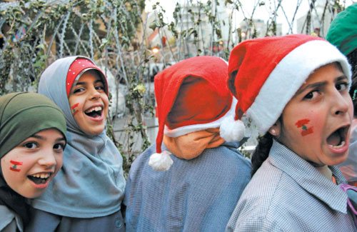 تلميذات من إحدى مدارس حزب الله يعتمرن قبّعات بابا نويل في وسط بيروت أمس (رويترز)