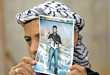 أحد أقارب الاستشهادي محمّد السكسك يحمل صورته في غزّة أمس (أ ب)