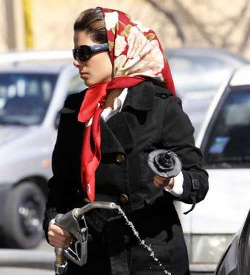 إيرانيّة تملأ سيّارتها بالوقود في محطّة في طهران أمس (رويترز)