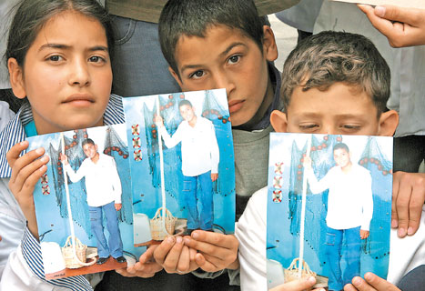 زملاء الضحية زياد غندور يحملون صورته أمام مدرسة وطى المصيطبة أمس (أ ب)