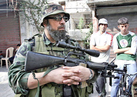 مسلح من قوة الفصل الإسلامية الفلسطينية في منطقة التعمير على مدخل مخيم عين الحلوة أمس (محمد الزعتري - أ ب)