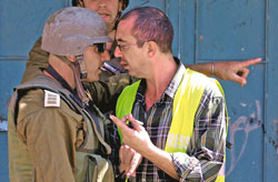 جندي اسرائيلي يجادل فلسطينيا في نابلس أمس (علاء برادني - إي بي أي)