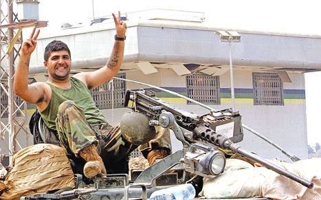 جندي لبناني يرفع راية النصر في محيط مخيّم نهر البارد (أنور عمرو - أ ف ب)