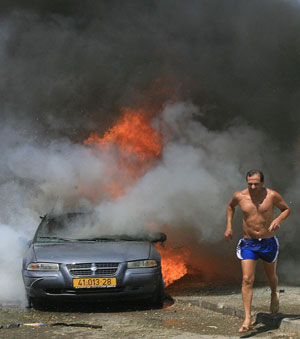 يهرب بعدما أحرق صاروخ كاتيوشا سيارته في كريات شمونة (أرشيف - أ ف ب)