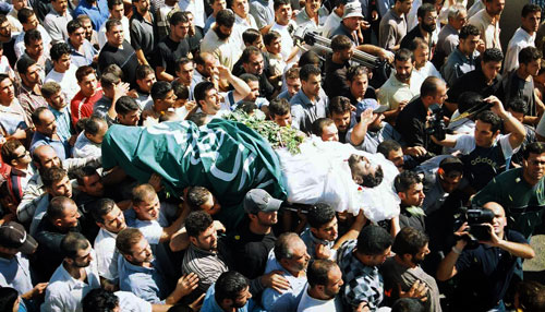 جثمان اللبناني إسماعيل الخطيب مرفوعاً على الأكفّ خلال مراسم التشييع في مجدل عنجر (أرشيف ـــ عفيف دياب)