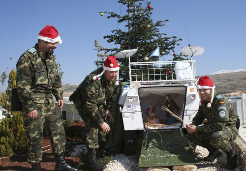 جنود من الفرقة الإسبانية في اليونيفيل يزينون إحدى آلياتهم العسكرية بمغارة الميلاد (كرم الله ضاهر ــ رويترز)