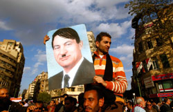متظاهر يرفع صورة لمبارك على هيئة هتلر (يانيس بيهراكيس ــ رويترز)