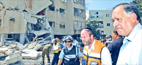 رئيس بلدية حيفا يونا ياهف في حي بات غاليم في حيفا بعد قصفه (أرشيف)