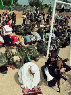 عالم دين يؤم الصلاة على ارض ملعب عين الحلوة مع مقاتلين من عصبة الانصار (خاص الأخبار)