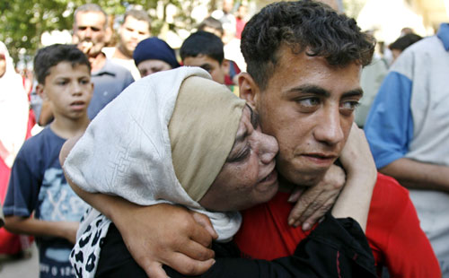 عناق بين ام وابنها بعد ان التقيا أمس في مخيم البداوي (لؤي ابو هيكل- رويترز)
