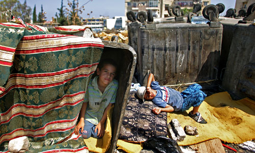 اطفال فلسطينيون يلهون بين القمامة في مخيم البداوي اول من امس (انور عمرو- أ ف ب)