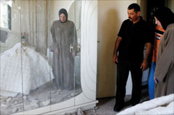 عائلة عكارية تتفقد الأضرار التي احدثها صاروخ اطلقه عناصر «فتح الإسلام» واصاب منزلها (عمر ابراهيم - رويترز)