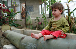 طفلة تجلس على بقايا قذيفة اسرائيلية حملت إلى زبقين آلاف القنابل العنقودية (حسن بحسون)