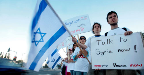 مجموعة من ناشطي السلام الإسرائيليّين يحملون العلم الإسرائيلي ويافطات تدعو إلى استئناف المفاوضات مع سوريا (