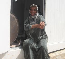 سيدة امام باب منزلها المؤقت في مخيم نهر البارد
