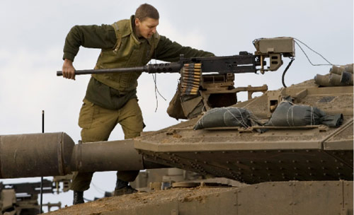 جندي إسرائيلي يجهّز سلاحه لاطلاق النار قرب الحدود مع غزة أمس (برنات أرمانغو - أ ب)