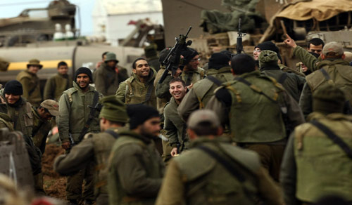 جنود إسرائيليون يتجمعون عند الحدود مع قطاع غزة أول من أمس (ميناهيم كاهانا - أ ف ب)