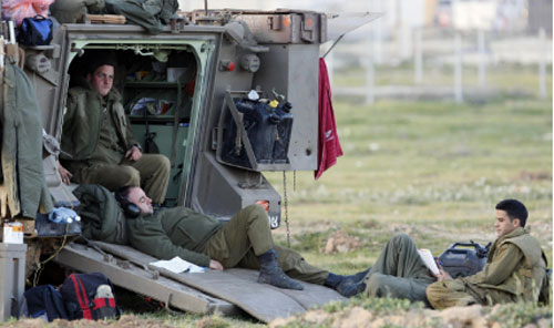 جنود إسرائيليون يرتاحون في موقعهم على حدود غزة أمس (جاك غوز - أ ف ب)