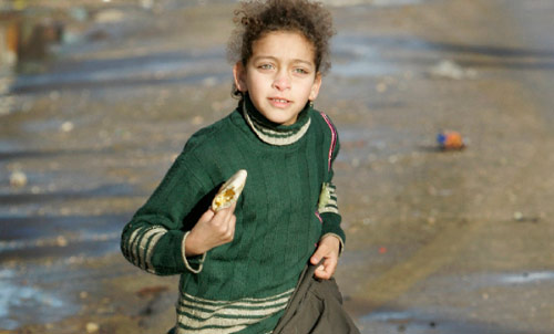 طفلة فلسطينية تهرع وراء عائلتها، عائدة إلى منزلها في رفح أمس (بن كورتيس - أ ب)