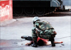 صورة وزعها الجيش لأحد أفراده يفكك الحزام الناسف عن جسد القتيل