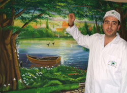 الحاج حسن أمام إحدى اللوحات التي ستدخل السجن