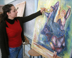 الطالبة روعة حدّارة أمام إحدى لوحاتها