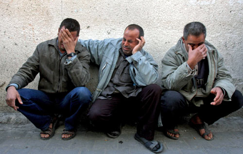 فلسطينيون يبكون استشهاد أقاربهم في شمال غزة أمس (خليل حمرا - أ ب)