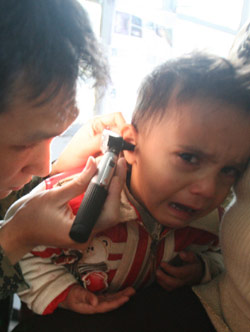 ضابط في الوحدة الكورية يعاين طفلا في منطقة صور (حسن بحسون)