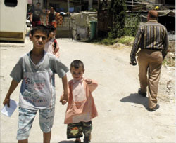 طفل يشير بيده إلى الكاميرا التي لا تغيب عن المخيمات هذه الايام