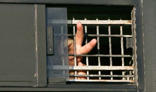 أسير فلسطيني يرفع شارة النصر خلال نقله إلى السجن.  (أرشيف ــ رويترز)