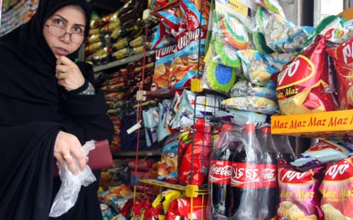ايرانية قرب زجاجات «الكوكاكولا» بعد حظرها في طهران أمس (عطا كناري - أ ف ب)