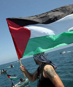 فلسطيني يلوّّح بعلم بلاده استعداداً لوصول «أسطول الحرية» (أرشيف ــ أ ف ب)