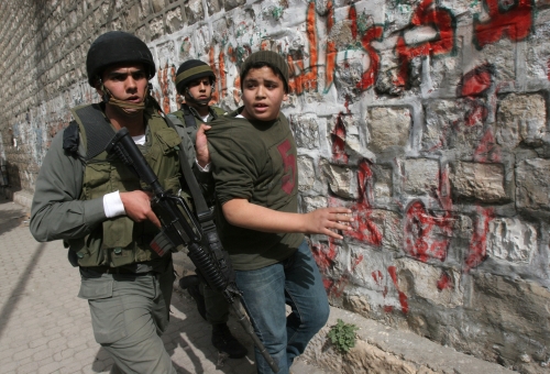 جنديّان إسرائيليّان يقتادان فتى فلسطينيّاً خلال حملة الاعتقالات في نابلس أمس (أ ب)