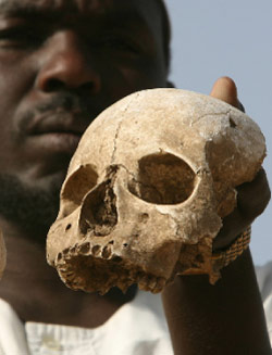 لاجئ سوداني يحمل جمجمة عثر عليها في درافور (أرشيف ــ أب)