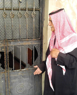 أحد المواطنين يشير الى آثار اعتداء على باب منزله في بلدة حوش بردى (الأخبار)