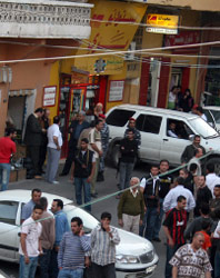 رجال أمن ومواطنون أمام محل أحد المشتبه فيهم في قانا (حسن بحسون)